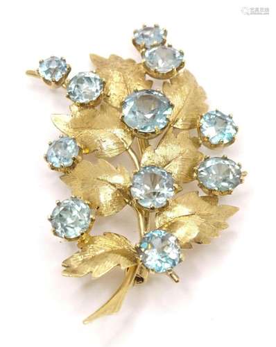 A 9ct gold brooch of leaf form set with blue zircon stones. ...