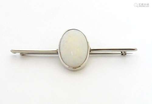 A 9ct white gold bar brooch set with central oval opal caboc...