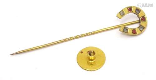 A 9ct gold stick pin surmounted by horseshoe decoration set ...