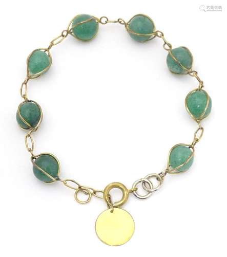 A 14kt gold bracelet with jade hardstone beads. Approx 7&quo...