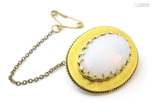 A yellow metal brooch set with opal cabochon. Approx. 1"...