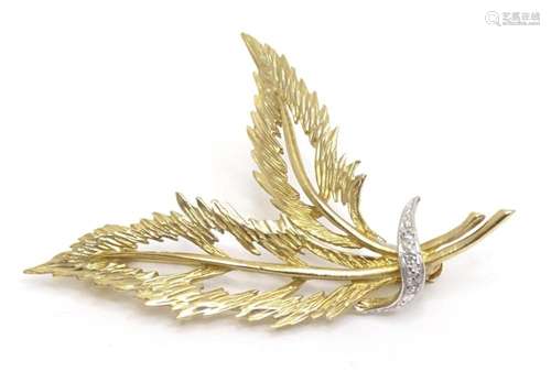 A 9ct gold brooch of feather form with chip set diamonds. Ap...