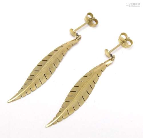 A pair of 9ct gold drop earrings formed as stylised feathers...