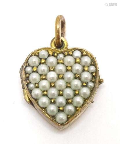 A gilt metal locket of heart form set with seed pearls. Appr...