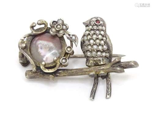 A Continental silver brooch modelled as a bird perched on a ...