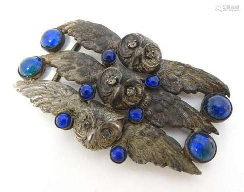 An early 20thC silver plate belt buckle with owl head decora...