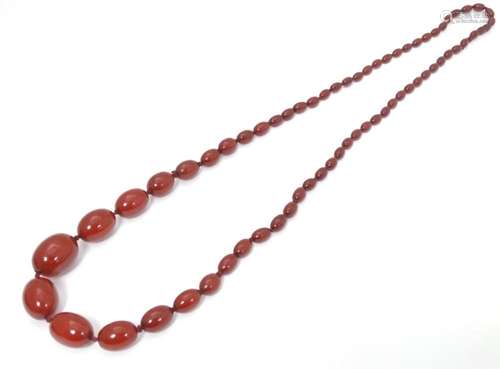 A cherry amber coloured bead necklace of graduated beads. Th...