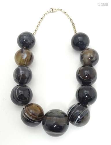 A bead necklace decorated with 11 hardstone agates spherical...