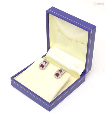 A pair of 9ct white gold earrings set with diamonds and rubi...