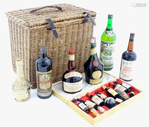 An old wicker hamper containing assorted fortified wines / s...