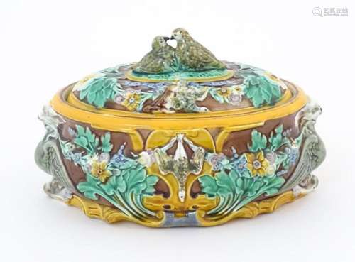 A majolica game pie dish and cover, the body decorated in re...