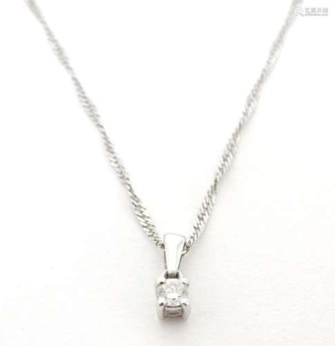 A 9ct white gold pendant set with diamond solitaire, on a 10...