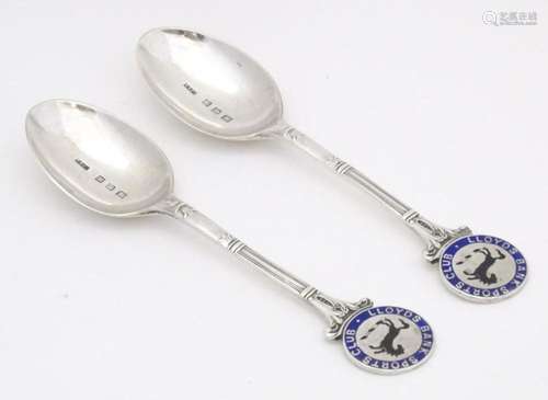 A pair of silver teaspoons the handles surmounted by Lloyds ...