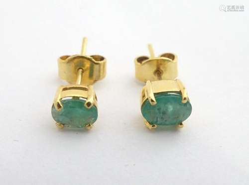 Gilt metal stud earrings set with green stones