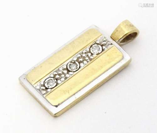 A 9ct gold pendant set with three diamonds. Approx 7/8"...