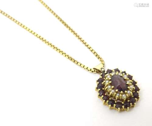 A 9ct gold pendant set with garnet and seed pearls, on a 9ct...