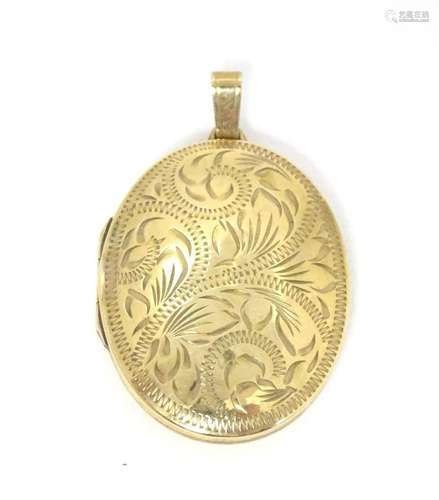 A 9ct gold pendant locket with engraved acanthus scroll deco...