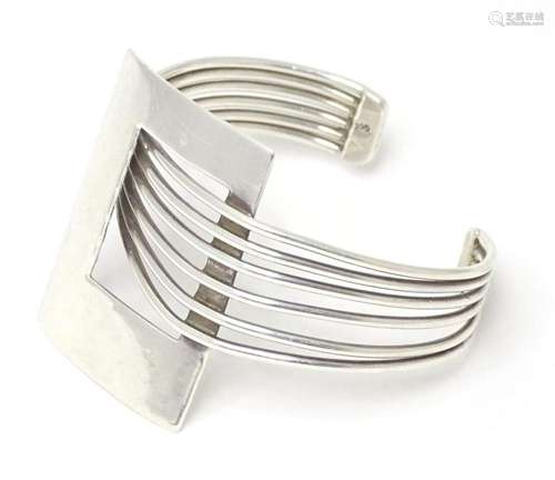 A silver modernist bracelet of bangle from