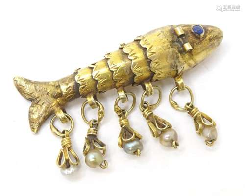 A yellow and gilt metal charm formed as an articulated fish ...