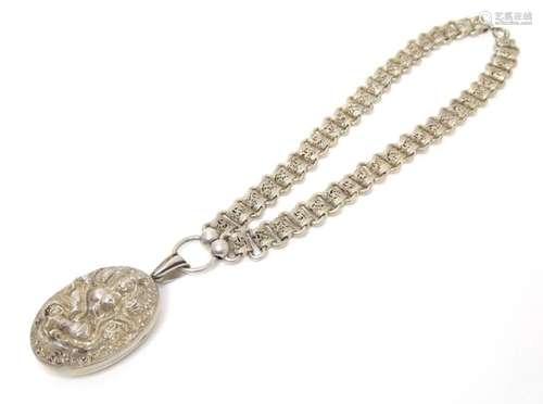 A white metal necklace with large oval locket depicting a de...