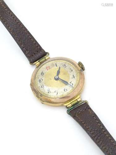 A 9ct gold cased wristwatch with Arabic numerals . The case ...