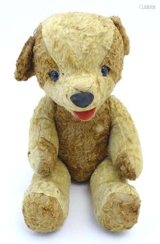 Toy: A 20thC straw filled teddy bear with leather tongue and...