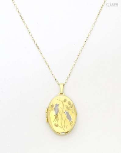 An oval yellow metal locket with engraved white metal bird a...