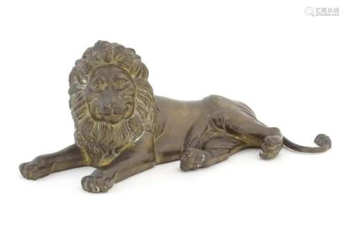 A 20thC cast brass model of a recumbent lion. Approx. 12 1/4...