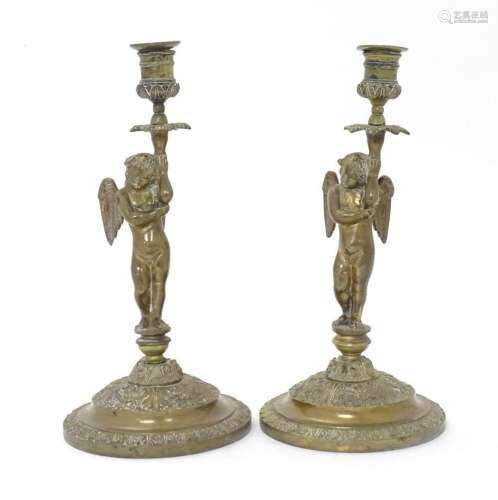 A pair of Victorian brass candlesticks, the columns modelled...
