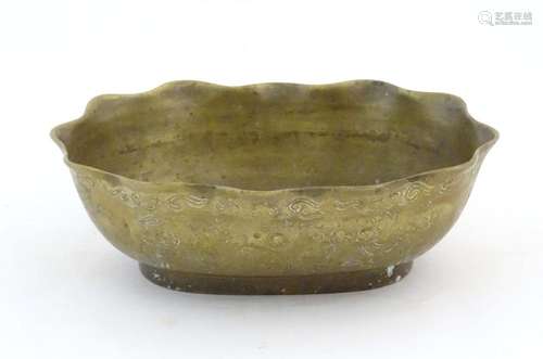 A Chinese oval brass bowl with a lobed rim, decorated with i...