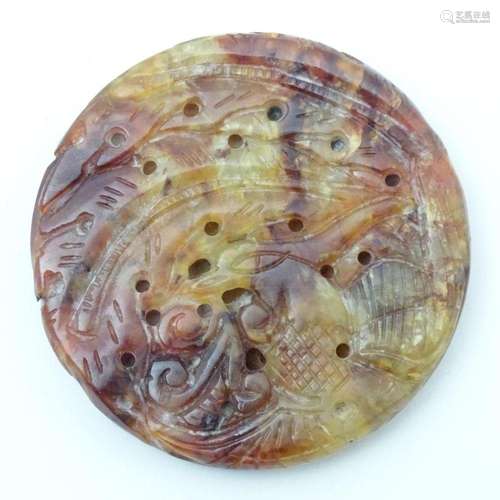 An Oriental hardstone roundel carving depicting stylised fol...