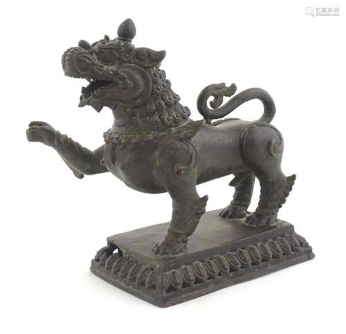 An Oriental cast temple lion with scrolled tail on a pierced...