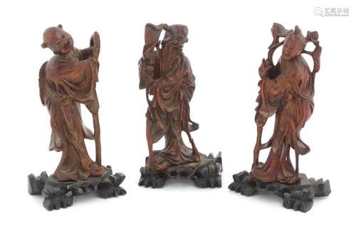 Three Oriental carved wooden figures to include an elder wit...