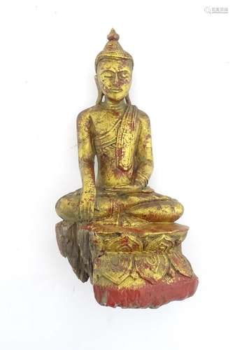 An Asian carved wooden model of a seated Buddha with polychr...