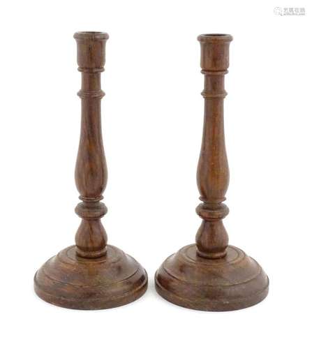 A pair of 20thC turned oak candlesticks. Approx. 11" hi...