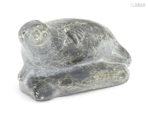 A 20thC Inuit soapstone carving modelled as a seal. Numbered...