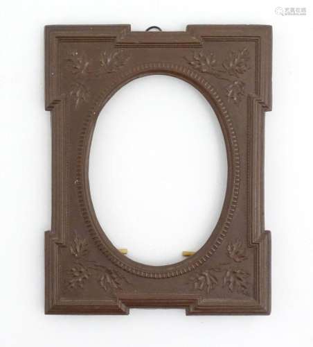 A 20thC Bakelite style photograph frame surround with an ova...