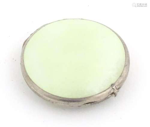 A small white metal compact of circular form with guilloche ...