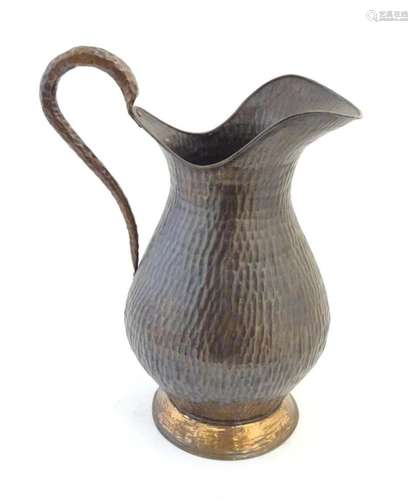 A large 20thC copper jug / pitcher with hammered decoration....