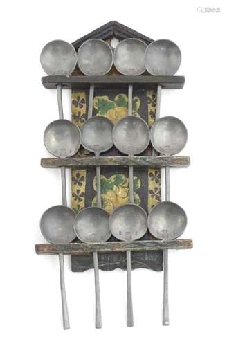 A 19thC Dutch wooden three tier spoon rack with arched pedim...