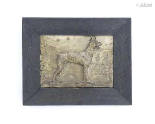 A 20thC German plaque cast in relief depicting a dog in a la...