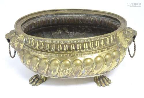 A 19thC brass wine cooler of oval form with embossed detail ...
