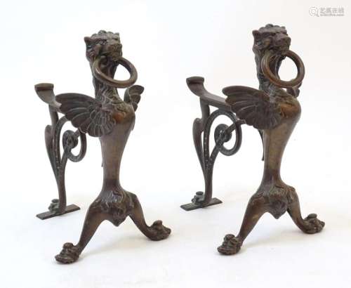 A pair of 20thC cast bronze fire dogs with winged griffin de...