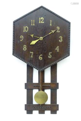 An Arts and Crafts style oak wall clock, the hexagonal dial ...