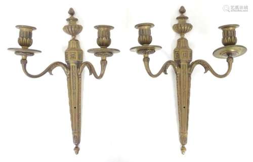 A pair of cast metal twin branch wall candle sconces with fl...