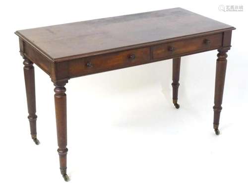 An early 19thC mahogany two drawer writing desk, having a mo...