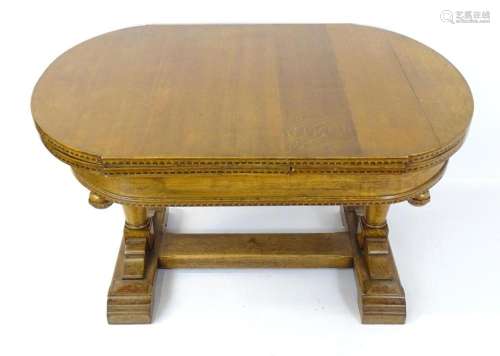 An early 20thC oak draw leaf dining table with an oval top w...