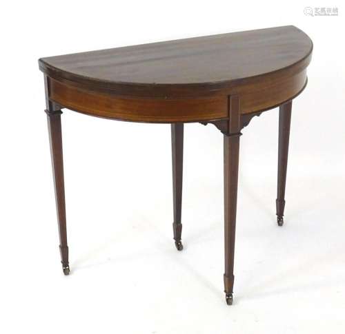 An early 20thC mahogany demi lune card table, having satinwo...