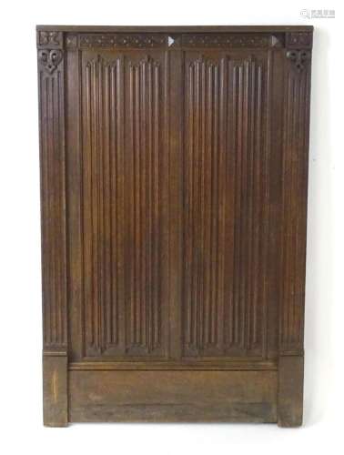 An early 20thC oak panel with carved rosettes and linen fold...