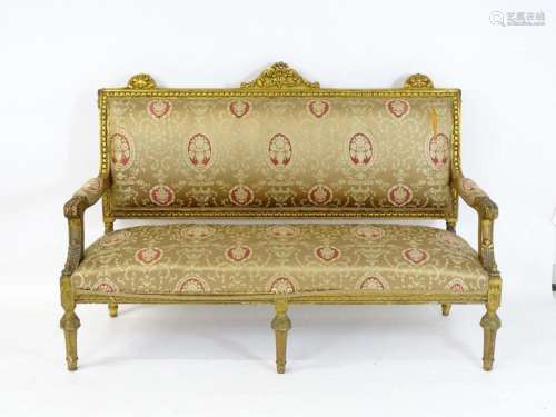 A late 20thC giltwood sofa with a floral carved frame, havin...